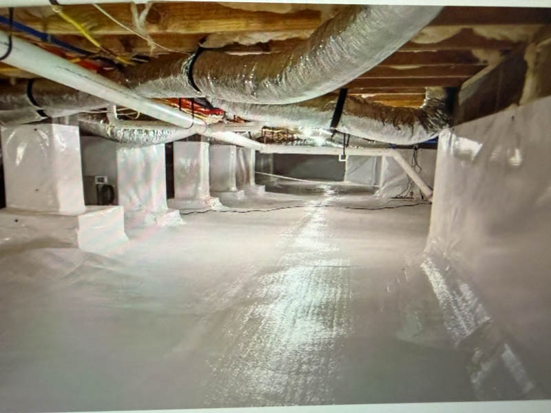 Crawl Space Encapsulation photo to keep moisture away from the frame of your house. Image shows a well sealed crawl space with clean, white 